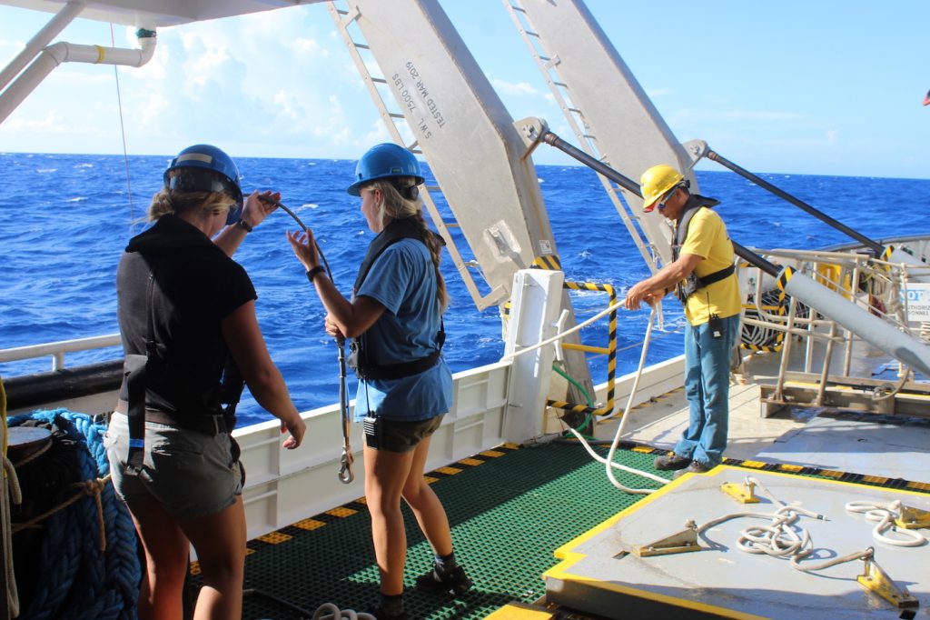 Ship technicians, suited up in safety gear, prepare to bring up the CTD.